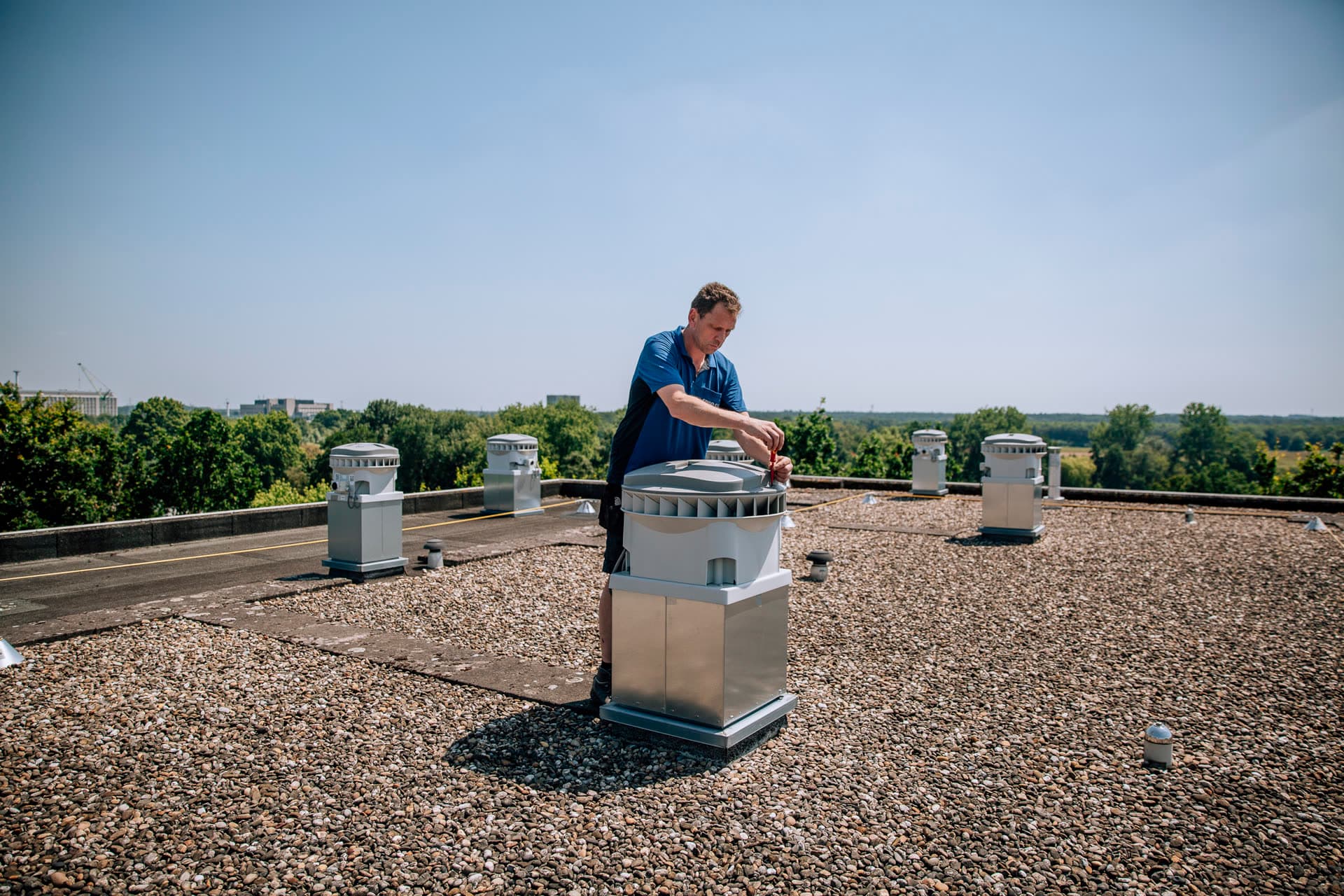 Monteur van Spiro Clean aan het werk bij ventilatie-units op een dak